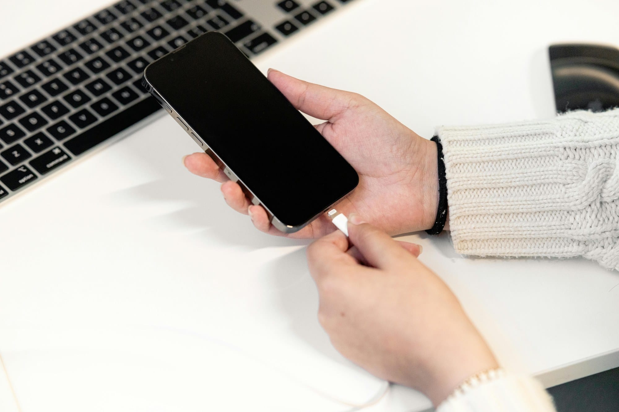 iPhoneを充電器に挿し込む手元