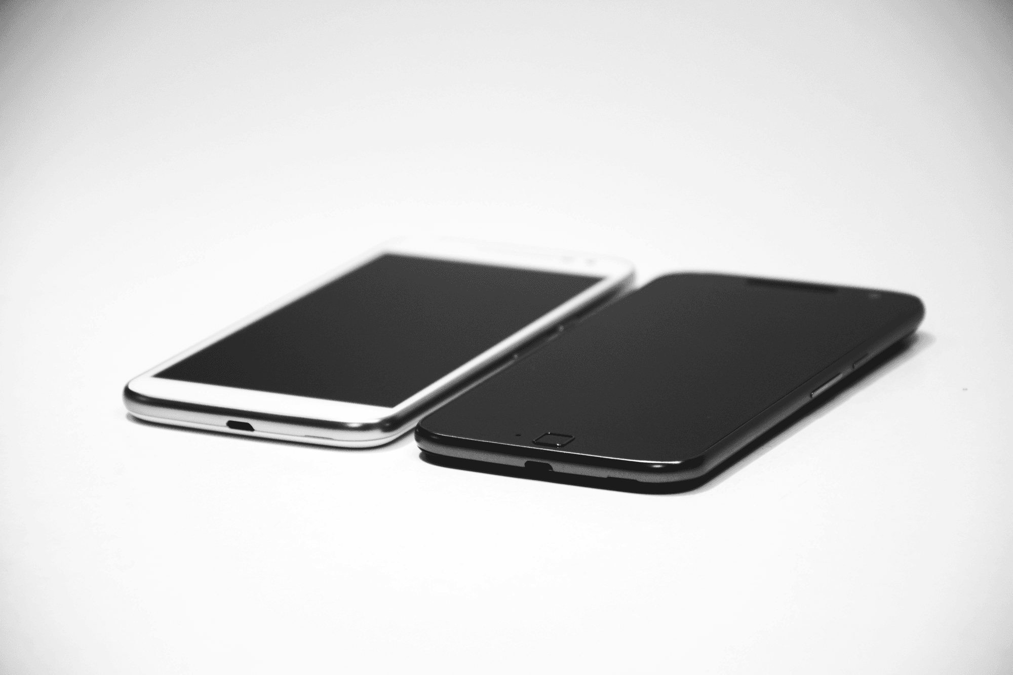 白と黒の2台のスマートフォン — iPhoneの連絡先を機種間で移行する手順