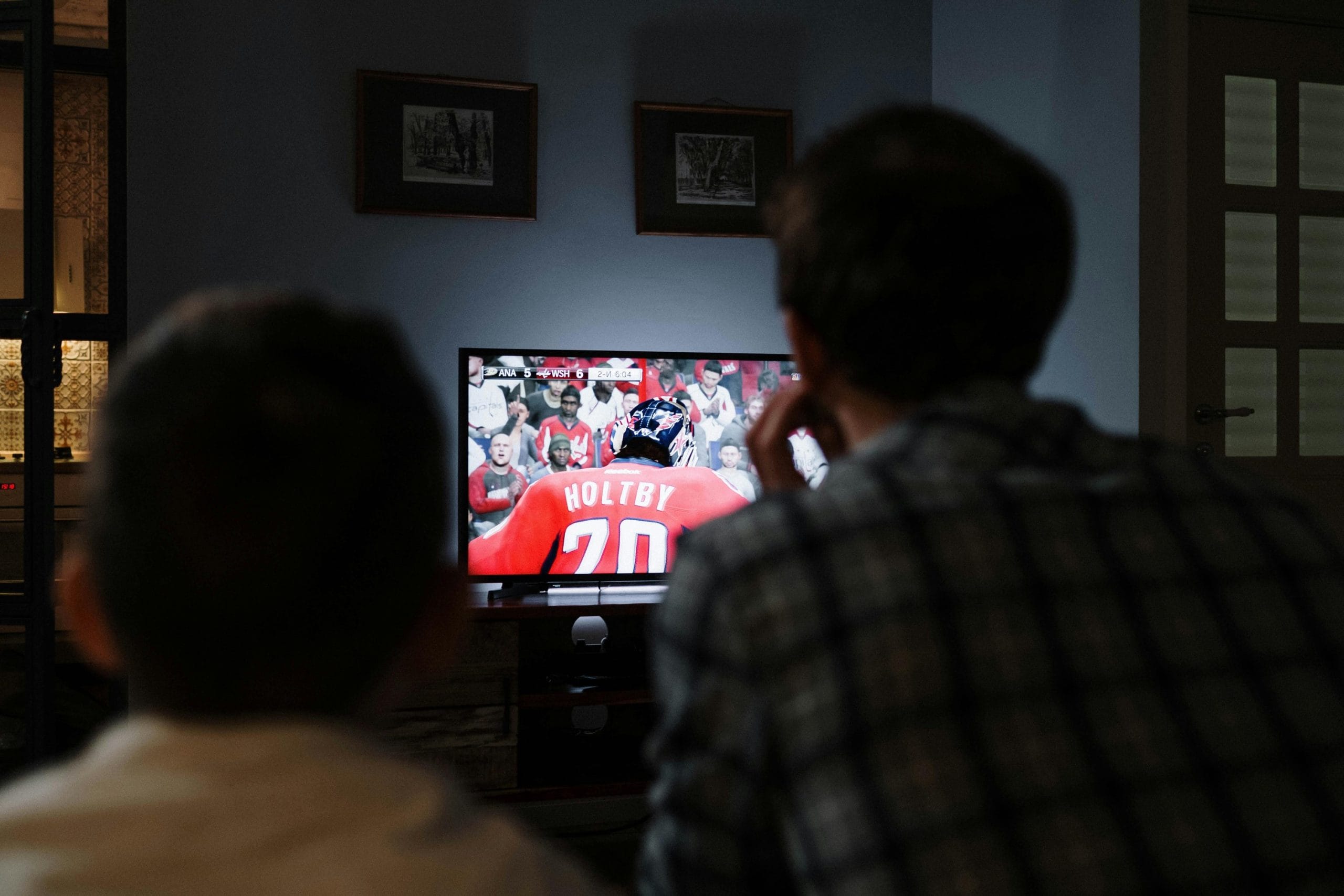 Family watching sports on a living room TV